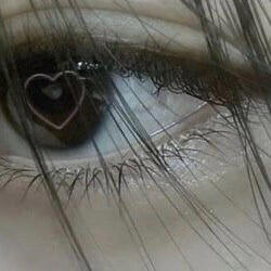 a brown/green eye with a light brown outline of a heart as the pupil.